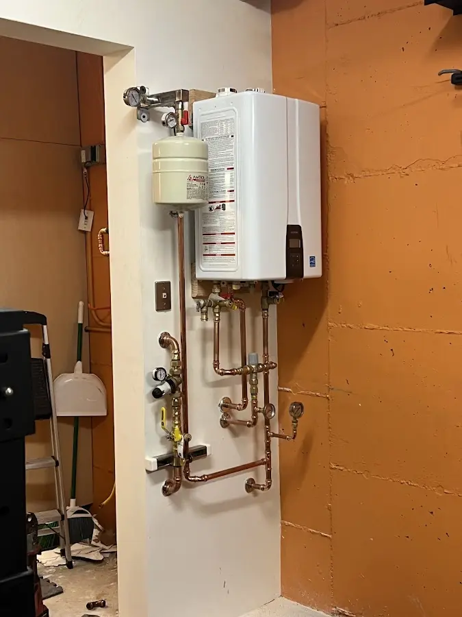 Plumbing technician inspecting water heater connections in Brownsville
